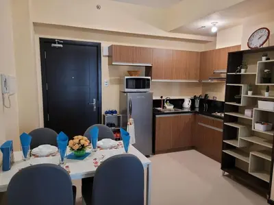 a kitchen with a table and chairs and a kitchen with a counter at The Radiance by Dominga in Manila