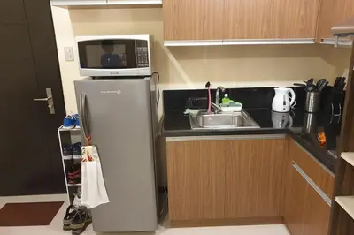 a microwave on top of a refrigerator in a kitchen at The Radiance by Dominga in Manila