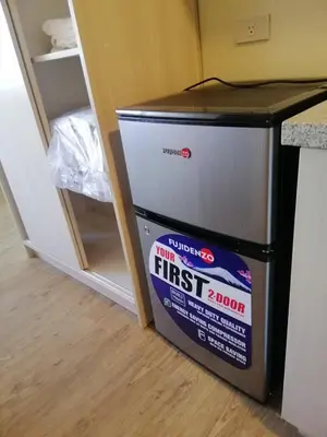 a box sitting on the floor next to a refrigerator at Stanford Suites 2 Lilian in Silang