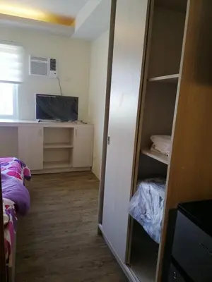 a room with a closet with a desk and a tv at Stanford Suites 2 Lilian in Silang