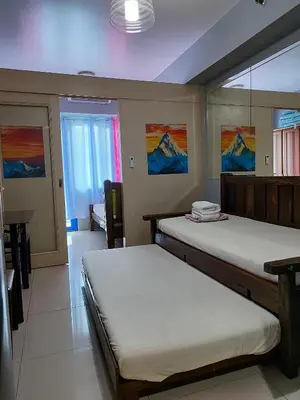 a bedroom with two beds and a table and a window at 5 Years Legit Staycation Infront of Moa, Arena, Smx, Ikea, Sea Residences Tower A, Near Dfa Macapagal, Ayala Mall, World Trade, Naia123 in Manila