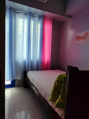 a bedroom with pink and blue curtains and a bed at 5 Years Legit Staycation Infront of Moa, Arena, Smx, Ikea, Sea Residences Tower A, Near Dfa Macapagal, Ayala Mall, World Trade, Naia123 in Manila