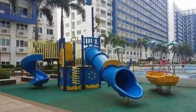 a playground with a slide in a park at 5 Years Legit Staycation Infront of Moa, Arena, Smx, Ikea, Sea Residences Tower A, Near Dfa Macapagal, Ayala Mall, World Trade, Naia123 in Manila