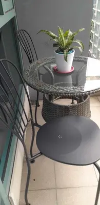 a patio table and chair with a potted plant on it at Le Maisse Executive Studio 1BR opp Okada in Manila