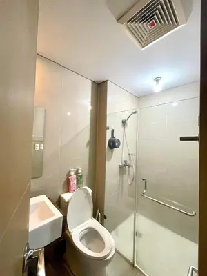 a bathroom with a toilet and a shower and a sink at Lovely 2 Bed Room condo infront of NAIA Terminal 3 in Manila