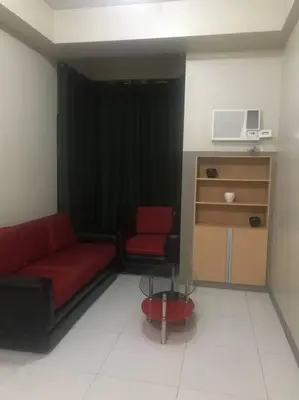 a living room with a red couch and a chair at Lovely 2 Bed Room condo infront of NAIA Terminal 3 in Manila