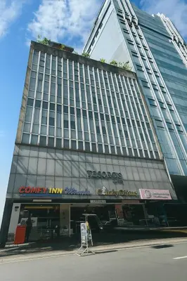 a large building with a sign in front of it at Comfy Inn Mabini Manila in Manila