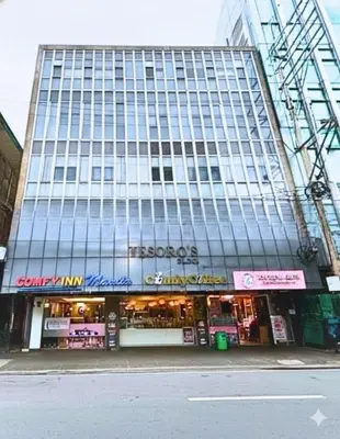 a large building with a store in front of it at Comfy Inn Mabini Manila in Manila
