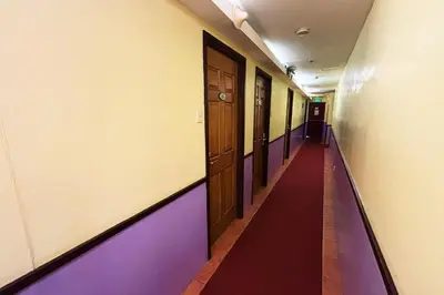 an empty hallway with a long red and purple corridor at Comfy Inn Mabini Manila in Manila