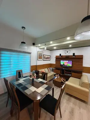 a living room with a table and a tv at 2 separate fully furnished condo units 1BR on the 23rd flr and 3BR penthouse on the 41st flr, with different bookings and daily rates in Ermita, Manila near SLEC,US Embassy, Mall and Parks in Manila