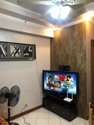a flat screen tv sitting on a stand in a room at 2 separate fully furnished condo units 1BR on the 23rd flr and 3BR penthouse on the 41st flr, with different bookings and daily rates in Ermita, Manila near SLEC,US Embassy, Mall and Parks in Manila