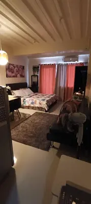 a bedroom with a bed and a desk with a desk at Katliza Condotel Kassel Residences in Manila
