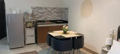 a kitchen with a table with a vase of flowers on it at Katliza Condotel Kassel Residences in Manila