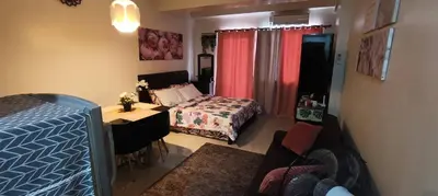 a bedroom with a bed and a desk and a table at Katliza Condotel Kassel Residences in Manila