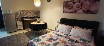 a bedroom with a bed and a table and a kitchen at Katliza Condotel Kassel Residences in Manila