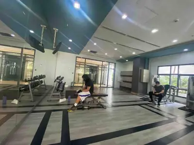 a woman sitting on a bench in a gym at 1BR Studio at viceroy McKinley taguig in Manila