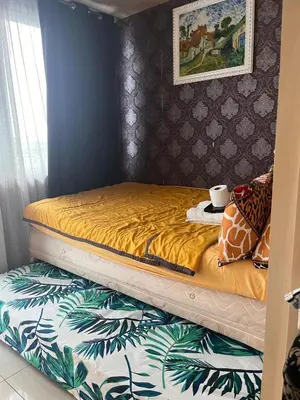 a bed in a bedroom with a yellow bedspread at Ronnzel staycation in Jazz Residence Makati in Manila