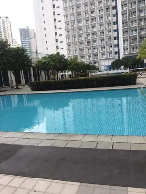 a large blue swimming pool in front of tall buildings at Ronnzel staycation in Jazz Residence Makati in Manila