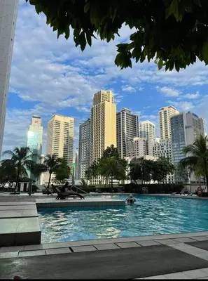a large swimming pool in a city with tall buildings at Ronnzel staycation in Jazz Residence Makati in Manila