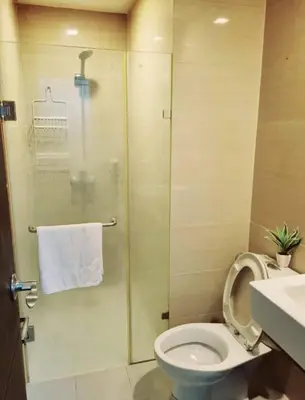 a bathroom with a shower with a toilet and a sink at 101 condo furnished walking distance NIAA 3 in Manila