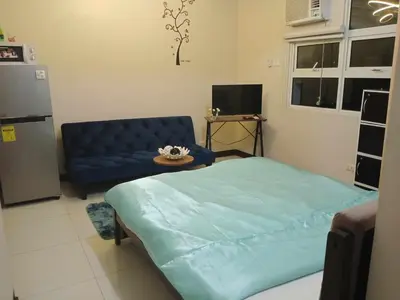 a living room with a blue bed and a couch at 101 condo furnished walking distance NIAA 3 in Manila