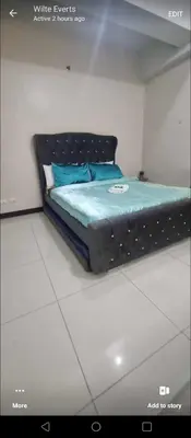a bedroom with a bed with a black bed frame at 101 condo furnished walking distance NIAA 3 in Manila