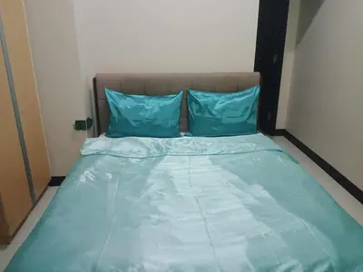 a blue bed with two blue pillows on it at 101 condo furnished walking distance NIAA 3 in Manila
