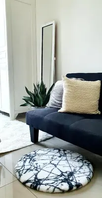 a living room with a blue couch and a rug at LukeatSkye Suite - The Beacon Makati in Manila