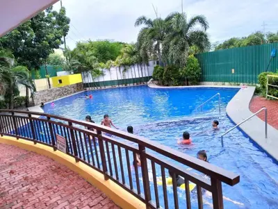 a group of people swimming in a swimming pool at Staycation budget room in Manila