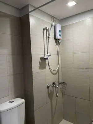 a shower in a bathroom with a toilet at Staycation budget room in Manila