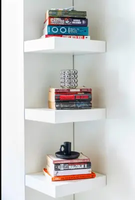 a stack of books on white shelves with a stack at Staycation in Manila (2 min. walk to Robinson's) in Manila