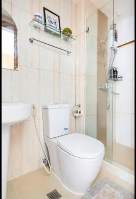 a bathroom with a toilet and a glass shower at Staycation in Manila (2 min. walk to Robinson's) in Manila