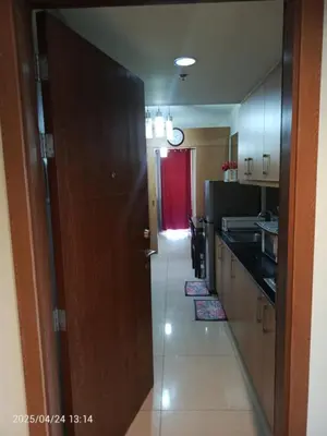 a hallway leading to a kitchen with a red door at Nice and Simple 1 Bedroom in Shell Residences in Manila