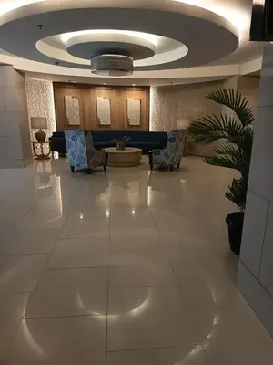 a lobby with a waiting room with chairs and a ceiling at Nice and Simple 1 Bedroom in Shell Residences in Manila