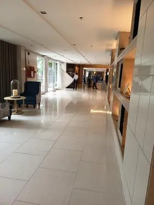 a hallway with white tile flooring in a building at Nice and Simple 1 Bedroom in Shell Residences in Manila
