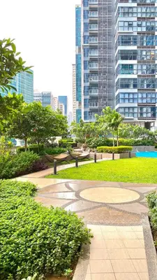 a park with benches and trees in a city at Lovely 1 Bedroom City View in Uptown BGC in Manila