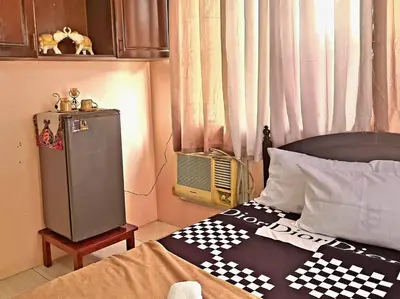 a bedroom with a checkered blanket on a bed at Affordable Condo for Rent near Emperor Events Place in Cainta