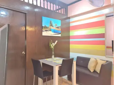 a dining room with a table and chairs and a colorful wall at Budget Friendly Staycation in Valley Mansions in Cainta