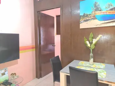 a dining room with a table with a vase on it at Budget Friendly Condo for Rent in Valley Golf in Cainta