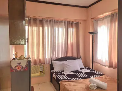 a small bedroom with a bed and a window at Budget Friendly Condo for Rent in Valley Golf in Cainta