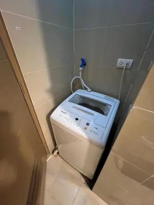 a washing machine in a bathroom with a wall at 2 Palm Tree Villas - Manila Terminal 3 Airport Pasay in Manila