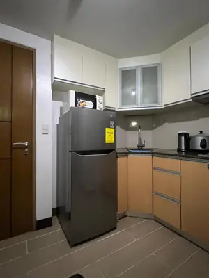 a kitchen with a stainless steel refrigerator and cabinets at 2 Palm Tree Villas - Manila Terminal 3 Airport Pasay in Manila