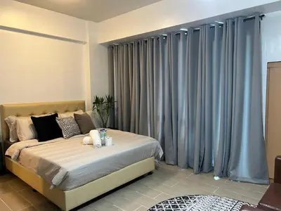 a bedroom with a bed with blue curtains at 2 Palm Tree Villas - Manila Terminal 3 Airport Pasay in Manila