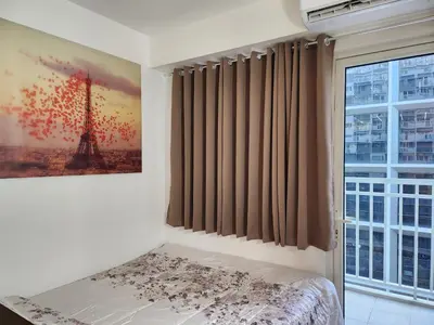 a bedroom with a view of the eiffel tower at Jana@ShoreC2 in Manila