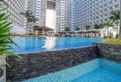 a large swimming pool in the middle of a building at Jana@ShoreC2 in Manila