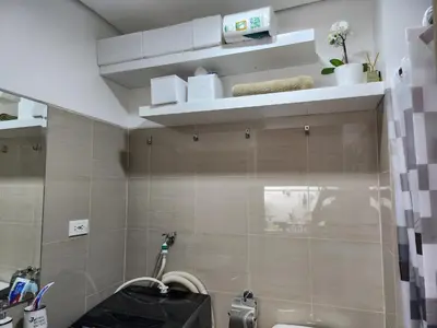 a bathroom with a sink and a toilet and shelves at Jana@ShoreC2 in Manila