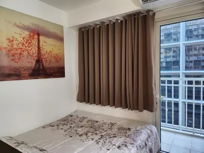 a bedroom with a bed and a window at Jana@ShoreC2 in Manila
