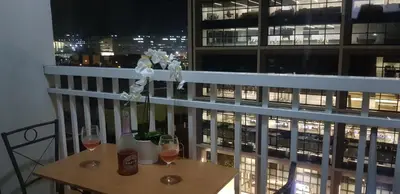 a balcony with a table and two glasses of wine at Jana@ShoreC2 in Manila