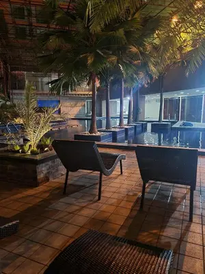 a lobby with two chairs and palm trees in a building at U806 2Bedrooms PoolAccess Netflix wifi85mbps Karaoke in Manila