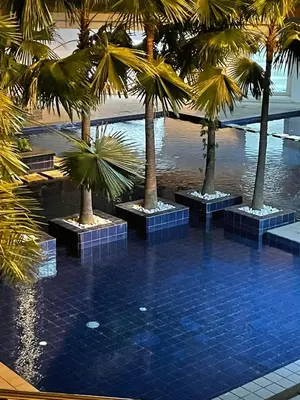 a swimming pool with palm trees in a building at U806 2Bedrooms PoolAccess Netflix wifi85mbps Karaoke in Manila